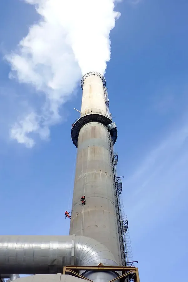 Operarios escalando silos industriales para inspeccionar su estado, capacidad y necesidades de mantenimiento.
